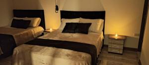 a bedroom with two beds and a night stand with lamps at Hotel Palo Grande in Manizales