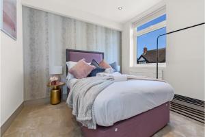 - une chambre avec un grand lit et une fenêtre dans l'établissement Lovely 1 bedroom apartment - Wembley Park, à Londres