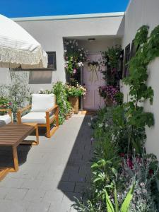 eine Terrasse mit einer lila Tür, einer Bank und Blumen in der Unterkunft Queenstown Retreat in Queenstown