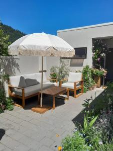 - une terrasse avec 2 canapés et un parasol dans l'établissement Queenstown Retreat, à Queenstown