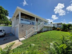 a house with a balcony and a yard at Villa Corazon in Sainte-Luce