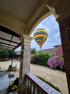 Une montgolfière survole une maison dans l'établissement Saphaothong guesthouse, à Vang Vieng