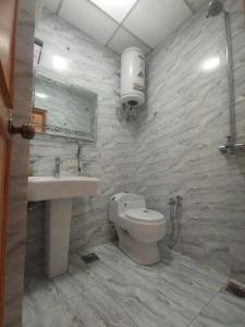 a bathroom with a toilet and a sink at Entire Apartment 2bed Condo at Burban Oakwood in Bhurban