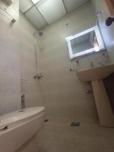 baño con aseo y lavabo y ventana en Entire Apartment 2bed Condo at Burban Oakwood, en Bhurban