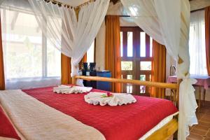 a bedroom with a red bed with a canopy at Samara Pacific Lodge in Sámara