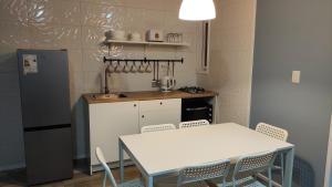 uma cozinha com uma mesa e uma mesa e cadeiras brancas em Cabaña 4-6 personas con piscina em Algarrobo