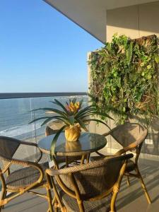 patio con mesa y sillas en el balcón en Luxury Beachfront Apartment - Morros City, en Cartagena de Indias