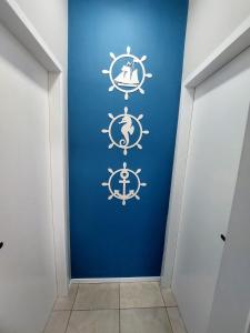 a hallway with a blue wall with nautical signs on it at Suite Praia Parque in Penha