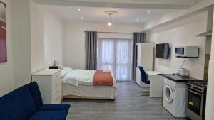 ein Hotelzimmer mit einem Bett und einer Küche in der Unterkunft Spacious 3-Bedroom Apartment - London in Wanstead