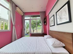 カンザーにあるCần Giờ Homestayのピンクのベッドルーム(大型ベッド1台、窓付)