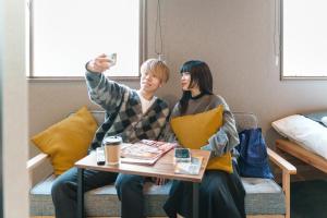 a man and a woman sitting on a couch with a table at BESTIE by DOYANEN in Osaka