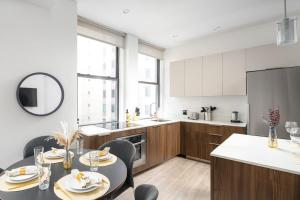 a kitchen with a table and chairs in a kitchen at Luxury 2BD nr Wall St Gym Rooftop w/d in New York