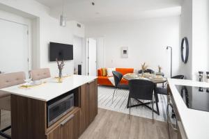 a kitchen and living room with a table and a couch at Luxury 2BD nr Wall St Gym Rooftop w/d in New York