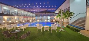 um pátio com cadeiras, uma mesa e uma piscina em CASABLU HOTEL&RESORT em Maribago