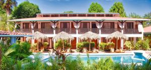 a hotel with a swimming pool in front of a building at Samara Pacific Lodge in Sámara