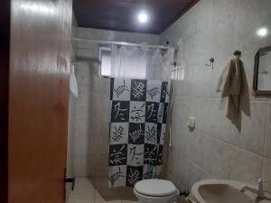 a bathroom with a toilet and a sink at Casa Winter - Seu Quarto Ideal in Santa Rosa
