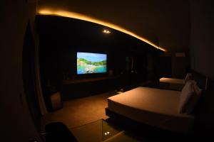 a dark room with a bed and a television at All in Motel in Garanhuns +4 photos