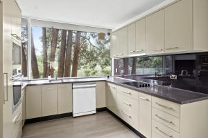 a kitchen with white cabinets and a large window at Cozy Double Room in Pymble Sleeps 2 in Pymble