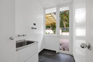 a white kitchen with a sink and a window at Cozy Double Room in Pymble Sleeps 2 in Pymble