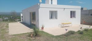 a small white house with a patio in a yard at Casa de Campo in Tanti