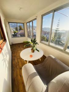 Pokój z kanapą, stołem i oknami w obiekcie Alojamiento Casa Nordica w mieście Taltal