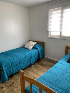 sypialnia z 2 łóżkami i oknem w obiekcie Alojamiento Casa Nordica w mieście Taltal