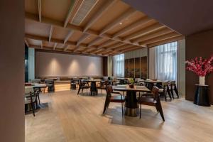 a dining room with tables and chairs and a projection screen at MSW Hotel Changzhou in Changzhou
