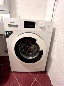 una lavadora blanca en una esquina de una habitación en Grand T2, en Annemasse