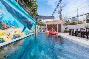 einen Pool mit einem Delphin-Wandbild an der Seite eines Hauses in der Unterkunft Villa 91 VTS - Gần Biển Thùy Vân - Sân Rộng Đãi Tiệc - BIDA - KARAOKE FREE in Vũng Tàu + 33 Fotos