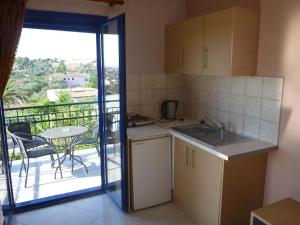 a kitchen with a sink and a table and a balcony at Michelle's Studios in Anaxos