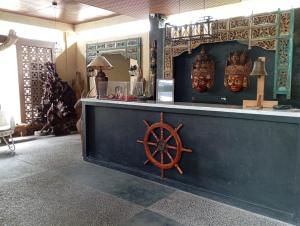 a bar with a wooden steering wheel and masks at The Culture Hotel And Gallery in Bogor