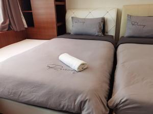 zwei Betten mit einem Papierhandtuch drauf in der Unterkunft EASTERN ORIENTAL STRAIT QUAY MARINA LUXURY SUITE in Tanjong Tokong