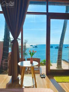 a room with a table and a view of the ocean at CHILL HOUSE by the beach in Phu Quoc