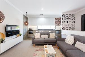 uma sala de estar com um sofá e uma televisão em Bambino 438 em Perth
