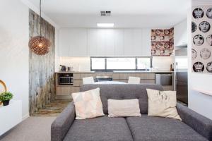a living room with a couch in front of a kitchen at Bambino 438 in Perth