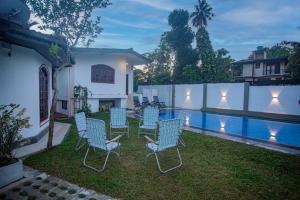 a backyard with chairs and a swimming pool at Villa 6070 in Galle