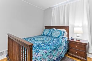 a bedroom with a bed with a blue comforter at The Cranbrook- Close to OSU-Downtown Columbus-Short North-Clintonville-Upper Arlington in Columbus