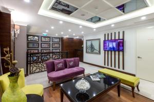 a living room with a purple couch and yellow chairs at Ferman Hilal Hotel-Special Category in Istanbul