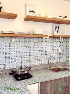 a kitchen counter with a sink and white tiles on the wall at Lovely Homes at Casa Mira Bacolod in Bacolod