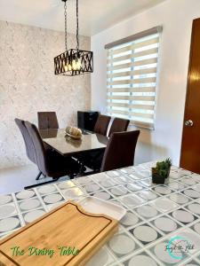 Lovely Homes at Casa Mira Bacolod في باكولود: غرفة طعام مع طاولة وكراسي