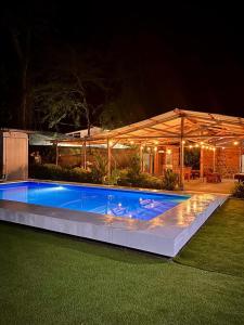 una piscina frente a una casa por la noche en Rustika Logde en Puerto Viejo