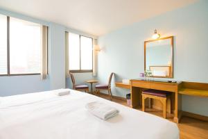 um quarto com uma cama, uma secretária e um espelho em Wish Inn Ratchaprasong - Chidlom วิช อินน์ ราชประสงค์ ชิดลม em Makkasan