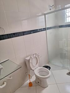 ein weißes Badezimmer mit Toilette und Dusche in der Unterkunft Casa para temporada em caraguatatuba praia do Massaguaçu in Caraguatatuba + 11 Fotos