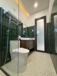 Un baño con inodoro, lavabo y ducha. en RiWin Hotel Pleiku, en Plei Brêng