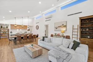 a living room and kitchen with a couch and a table at Bella Beach Resort - An Oasis on the Bellarine with heated pool in Saint Leonards
