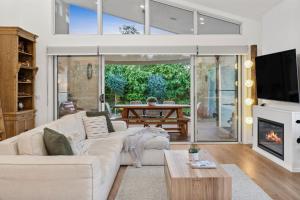 Bella Beach Resort - An Oasis on the Bellarine with heated pool في سانت ليوناردز: غرفة معيشة مع أريكة ومدفأة