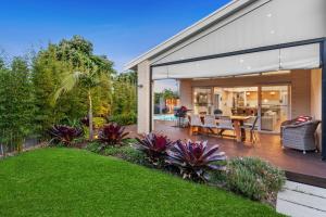 a house with glass doors and a patio with a table at Bella Beach Resort - An Oasis on the Bellarine with heated pool in Saint Leonards