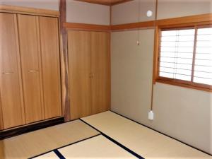 pusty pokój z drewnianymi szafkami i oknem w obiekcie Corpo Umeyama 2F / Vacation STAY 3912 w mieście Mibu
