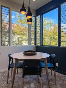 a dining room with a table and chairs and windows at 3BR Stylish Residence in Los Angeles - OL in Los Angeles