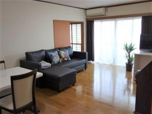 salon z kanapą i stołem w obiekcie Corpo Umeyama 2F / Vacation STAY 3912 w mieście Mibu